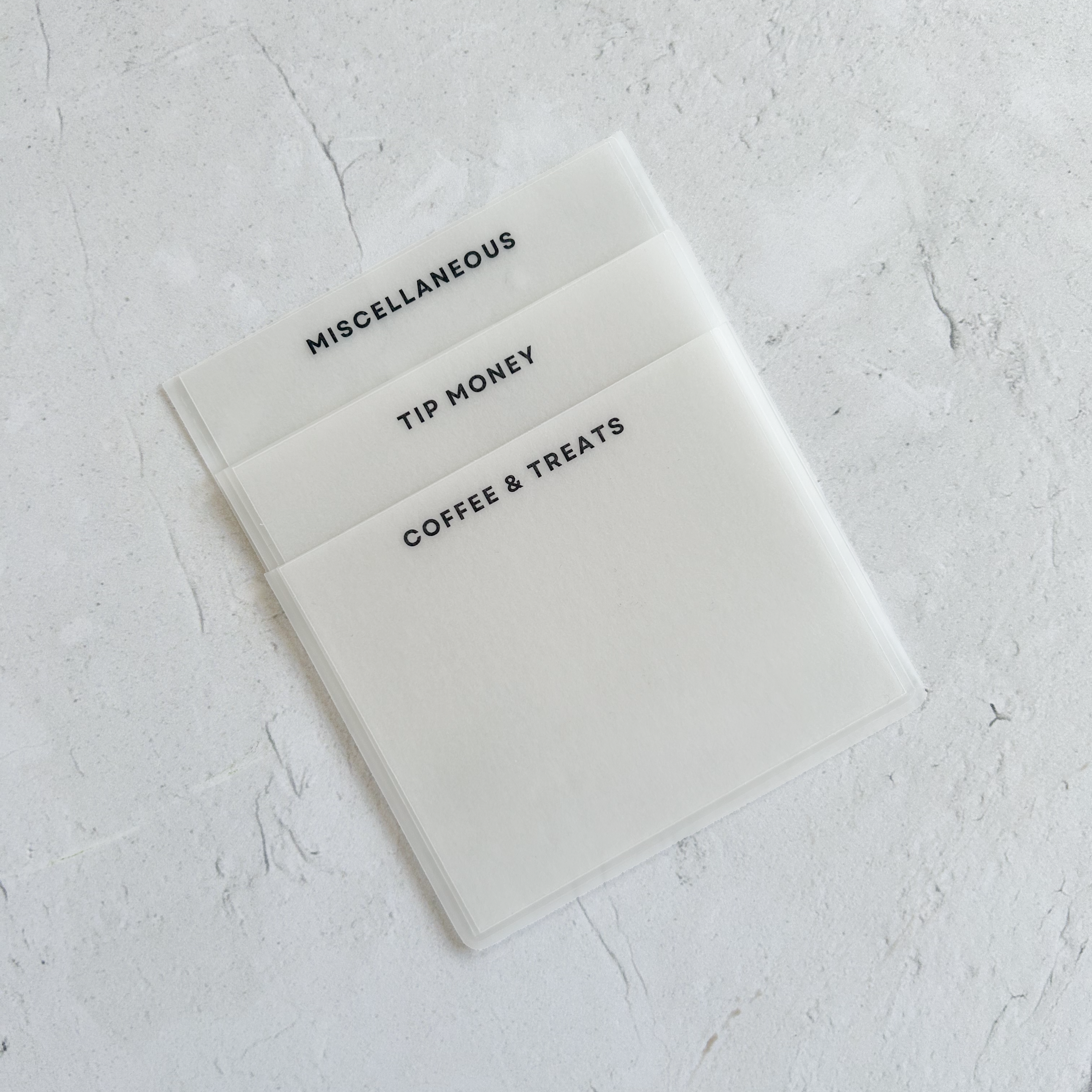 Three vellum cash envelopes with black ink labels