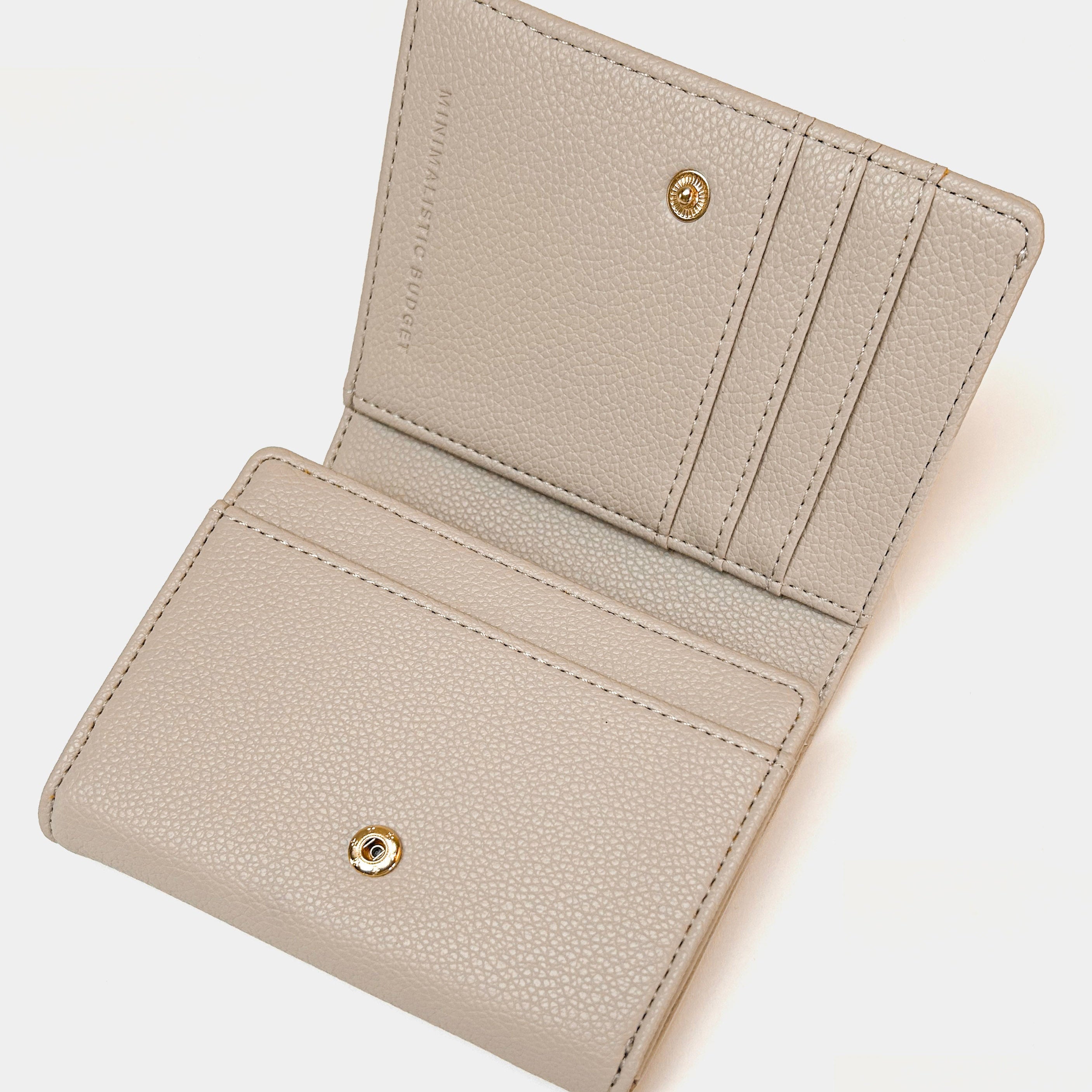 Beige wallet with gold accents on a white background