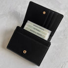 Black leather wallet with card holder on a light gray background