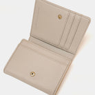 Beige wallet with gold accents on a white background