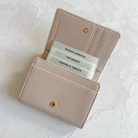 Beige wallet with card compartments on a light gray background